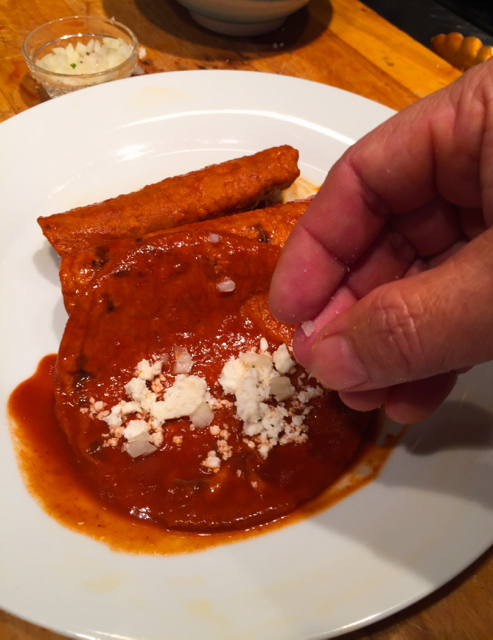 Enchiladas filled with tiny bits of white onion and queso fresco