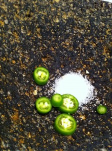 Chile serrano and salt in a molcajete, ready for the first step in making guacamole.