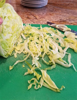 Serrano shrimp cocktail rests on a bed of thinly sliced lettuce